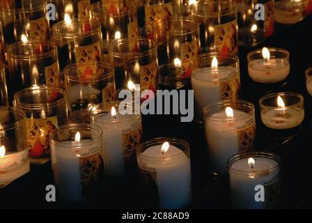 Des bougies votives scintillent de petits espaces dans l'intérieur sombre de la basilique Sainte-Marie-Madeleine, l'église d'une ancienne abbaye bénédictine à Vézelay, Yonne, Bourgogne, France. L'église a été reconstruite et agrandie au XIIe siècle pour faire face à des hordes de pèlerins voyageant à des os vénérés conservés dans la crypte, considérés comme des reliques de Sainte Marie-Madeleine. L'église abbatiale a été ajoutée à la liste des sites du patrimoine mondial de l'UNESCO en 1979. Banque D'Images