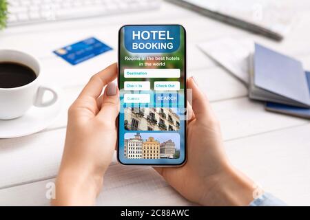 Gros plan sur un smartphone avec application de réservation d'hôtel entre les mains des femmes Banque D'Images