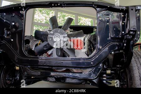 Roue de ventilateur d'un moteur V8 intégré dans une coque de carrosserie d'une voiture de muscle. Banque D'Images