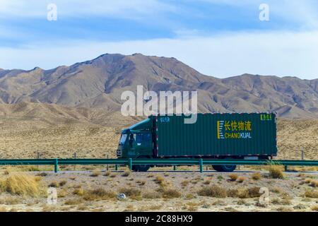 Le camion vert conduisant sur l'autoroute Qinghai - Tibet. Longue autoroute sur le désert de gobi, la route a été le vent de sable avec le fond sauvage à Qingha.Chine Banque D'Images
