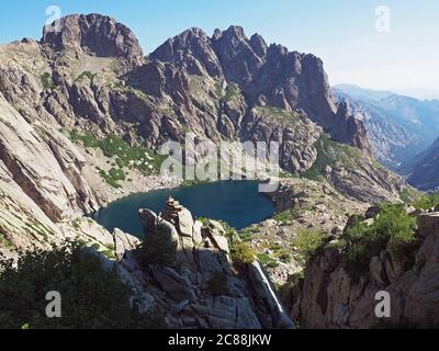 magnifique paysage de lac de haute montagne dans les alpes corsiciennes avec des rochers buissons verts et ciel bleu sur le gr20 célèbre trek Banque D'Images