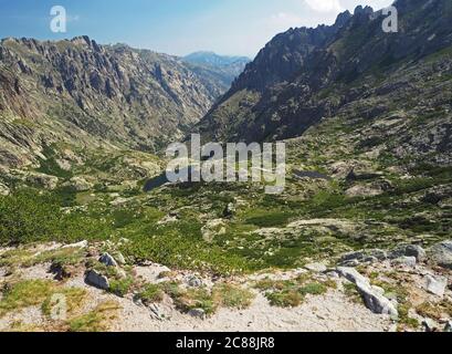 magnifique paysage de deux lacs de haute montagne dans les alpes corsiciennes avec des rochers buissons verts et ciel bleu sur le célèbre trek gr20 Banque D'Images