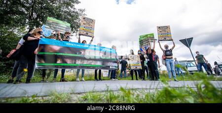 22 juillet 2020, Rhénanie-du-Nord-Westphalie, Rheda-Wiedenbrück: Des militants des droits des animaux de l'Office allemand de protection des animaux manifestent devant l'usine de viande de Tönnies avec des bannières et des panneaux. Leur devise est: 'Tönnies tue! Les gens souffrent, les animaux meurent. Depuis la semaine dernière, l'abattoir est de nouveau ouvert. Actuellement, jusqu'à 10,000 porcs y sont tués chaque jour. Photo: David Inderlied/dpa Banque D'Images