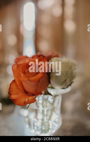 Mise au point verticale sélective de vase en verre de roses sur table de mariage Banque D'Images