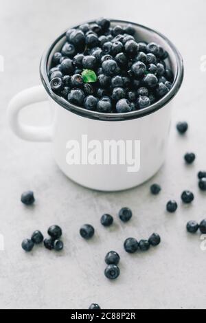 Bleuet frais avec gouttes d'eau dans un bol blanc. Vue de dessus. Concept de manger sain et diète. Fond de fruits de saison biologiques sains. Banque D'Images