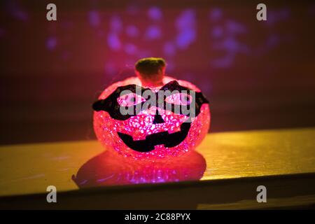Lanterne originale de type ninja Jack-o'. Belle vue rapprochée de cette citrouille en plastique inhabituelle. Port d'un masque sombre et rouge éclatant. Décoration d'halloween effrayante. Banque D'Images