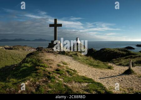 Côte nord du pays de Galles avec une croix et le phare de Llanddwyn, Royaume-Uni Banque D'Images