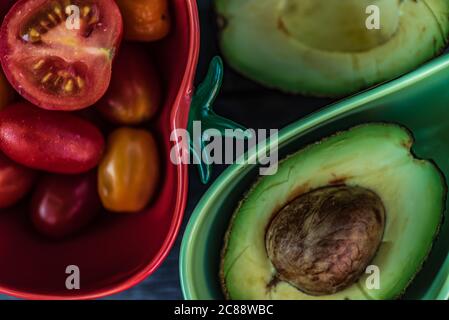 Deux bols qui sont adaptés pour les tomates et les avocats dehors sur une table Banque D'Images