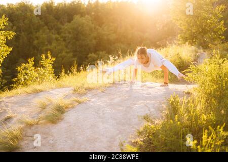 Belle femme sportive qui pose un pompier. Fille faisant des exercices de yoga avancés, se penchent sur les mains Banque D'Images