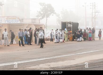 Bangalore, Karnataka, Inde - 10 janvier 2013 : groupe de personnes attendant un autocar dans la brume tôt le matin à la périphérie de la ville de Bangalore, Inde Banque D'Images