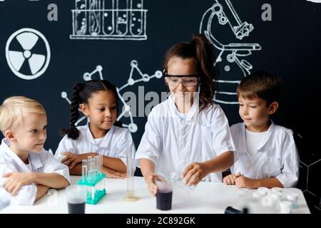 Les jeunes enfants multiraciaux actifs en profite pour mettre leurs compétences et leurs connaissances en pratique dans un projet d'équipe qui est le meilleur de son niveau d'éducation. Banque D'Images