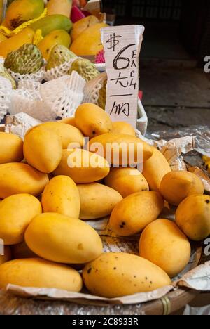 Groupe de mangues à vendre sur le marché sec de Hong Kong, produits biologiques importés de dégustation de sucreries, source de fibres et de vitamines. Banque D'Images