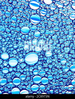 Vue de dessus sur les gouttes d'huile colorées sur l'eau. Cercles et ovales. Banque D'Images