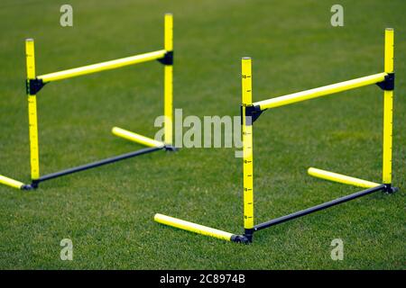 Obstacles à l'entraînement jaune sur le terrain d'entraînement sportif. Deux obstacles en ligne pour la pratique de saut. Matériel de classe d'éducation physique Banque D'Images