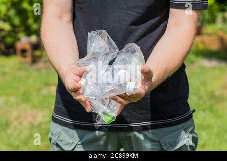 Homme tenant des bouteilles en plastique écrasées dans ses mains, concept, mode de vie écologique, zéro déchet Banque D'Images