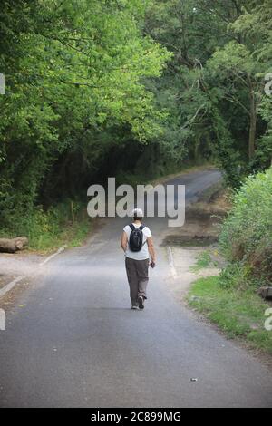 vue arrière d'une marchette seule sur une route de campagne Banque D'Images