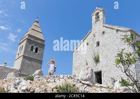 Visite d'une femme dans un ancien village côtier de Lubenice sur l'île de Cres, Croatie Banque D'Images