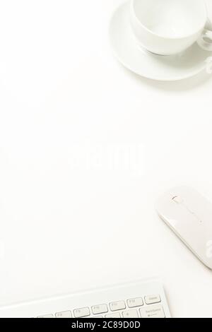 clavier, souris et gobelet vide sur bureau blanc avec espace pour copier Banque D'Images