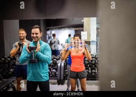 Forme physique, sport, entraînement, salle de sport, succès et concept de style de vie. Groupe d'amis heureux dans la salle de gym Banque D'Images