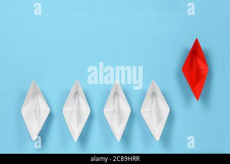 bateau en papier rouge, leader de la course contre les bateaux en papier blanc, concept abstrait Banque D'Images