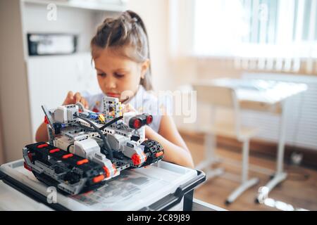 Écolière tenant un robot constructeur en classe robotique Banque D'Images