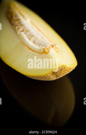 Studio de photo de melon mûr à encoches galia avec une tranche isolée sur fond noir Banque D'Images