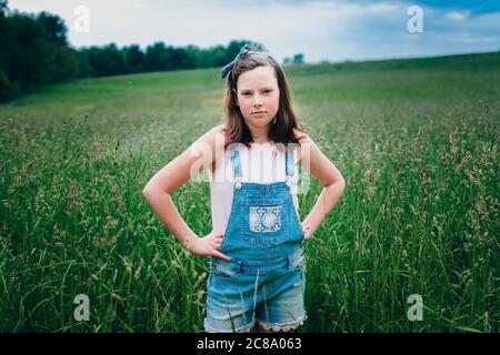 Teen Girl dans le short général debout dans Grassy Field dans Le Midwest Banque D'Images