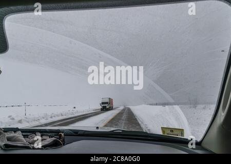 Vue hors du pare-brise du camion roulant sur route en cas d'orage de neige Banque D'Images