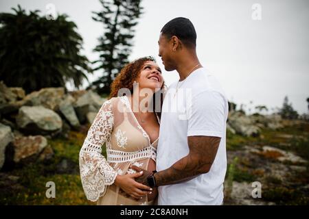 Photos de maternité de couple de race mixte sur la plage Banque D'Images