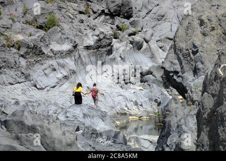 Un jeune couple tient les mains dans une gorge de roche volcanique de la rivière Simeto, un des points de repère de la nature sicilienne Banque D'Images