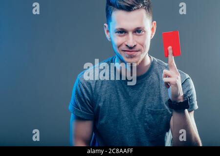homme tenant une carte de crédit sur fond sombre Banque D'Images
