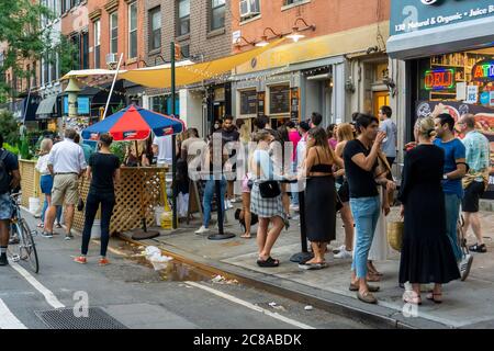 La foule se rassemble à l'extérieur de la baignoire Gin dans le quartier de Chelsea, à New York, tandis que le bar célèbre son 9e anniversaire avec une fête le jeudi 16 juillet 2020. Gov. NYS Andrew Cuomo annoncera des plans pour que la ville entre dans la phase 4 de sa réouverture, mais aucune activité intérieure supplémentaire ne sera autorisée, citant partiellement les problèmes de non-conformité des bars et des restaurants. (© Richard B. Levine) Banque D'Images