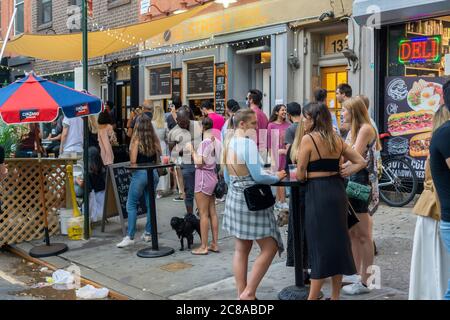 La foule se rassemble à l'extérieur de la baignoire Gin dans le quartier de Chelsea, à New York, tandis que le bar célèbre son 9e anniversaire avec une fête le jeudi 16 juillet 2020. Gov. NYS Andrew Cuomo annoncera des plans pour que la ville entre dans la phase 4 de sa réouverture, mais aucune activité intérieure supplémentaire ne sera autorisée, citant partiellement les problèmes de non-conformité des bars et des restaurants. (© Richard B. Levine) Banque D'Images