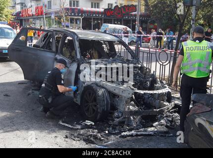 Des experts de la police ukrainienne enquêtent sur les lieux de la BMW X5 brûlée, après l'incendie dans le centre-ville de Kiev. L'incendie a englouti deux voitures BMW X5 et Acura, qui étaient garées sur la route, a informé le Service d'Etat de l'Ukraine pour les urgences facebook page. A la suite de l'incendie, la BMW X5 a été complètement détruite et l'Acura partiellement détruite. La cause de l'incendie est actuellement établie par la police. Il n'y a pas de victimes. Banque D'Images