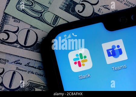 Stone / Royaume-Uni - juillet 22 2020 : applications Slack et Microsoft Teams sur l'écran du coin du smartphone placé sur l'arrière-plan des factures en dollars. Concept pour c Banque D'Images