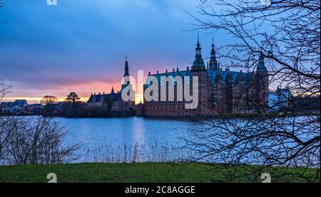 Château de Frederiksborg au coucher du soleil, avec lac et arbre en premier plan, Hillerod, Danemark Banque D'Images