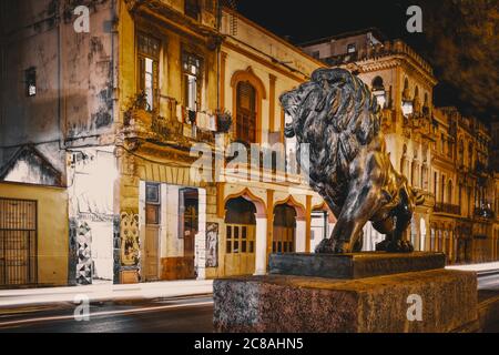 Scène nocturne avec le célèbre lion de bronze et vue sur les vieilles maisons le long de l'avenue El Prado dans le centre de la Havane Banque D'Images