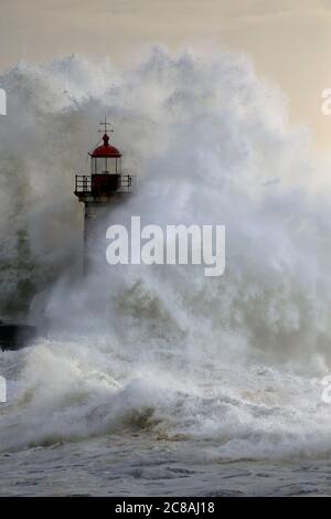 Vieux phare à l'embouchure du Douro pendant la tempête en mer au coucher du soleil. Banque D'Images