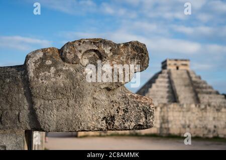 Une jaguar en pierre sculptée se dirige à la Grande salle de bal dans les ruines de la grande ville maya de Chichen Itza, Yucatan, Mexique. Derrière se trouve le Grand Pyramid Banque D'Images