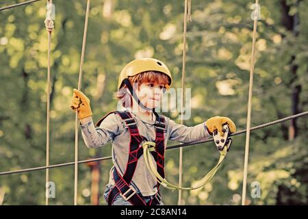 Aventure escalade High Wire Park. Adorable enfant d'école appréciant une journée ensoleillée dans un parc d'activités d'escalade. Enfants jouant sur l'aire de jeux Banque D'Images