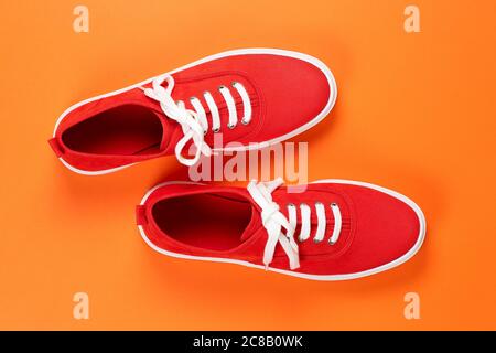 paire de chaussures en daim rouge sur une surface orange Banque D'Images