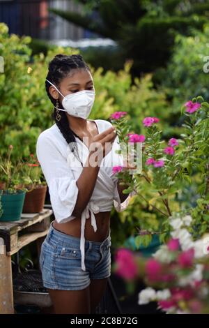 Jeune femme jardinage dans le masque de visage Banque D'Images