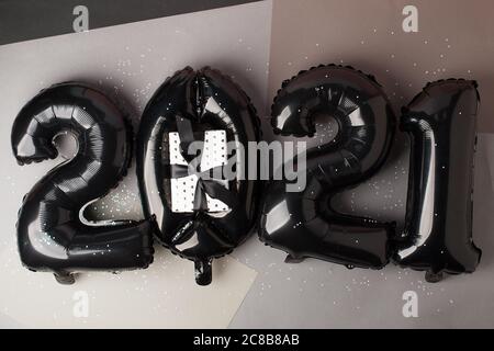 Noël nouvel an 2021 numéros ballons Air noirs élégants sur gris. Célébration, arrière-plan créatif des fêtes de saison, pose à plat, bannière pour le site, partie Banque D'Images
