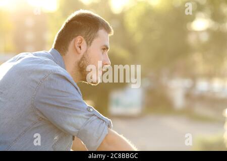 Homme pensif contemplant une vue sur un balcon Banque D'Images