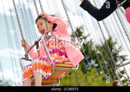 Les enfants apprécient la promenade dans un carrousel pendant un après-midi ensoleillé au Heritage Park de Calgary, Alberta Banque D'Images