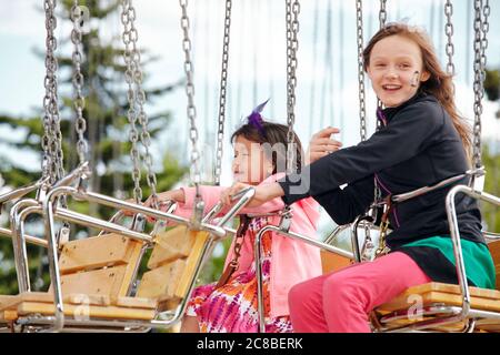 Les enfants apprécient la promenade dans un carrousel pendant un après-midi ensoleillé au Heritage Park de Calgary, Alberta Banque D'Images