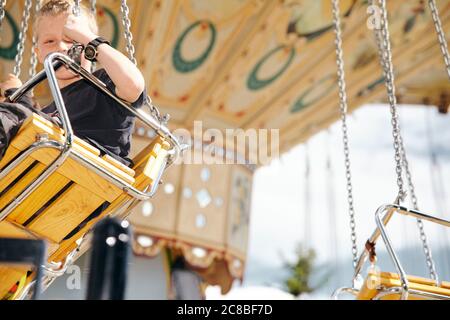 Les enfants apprécient la promenade dans un carrousel pendant un après-midi ensoleillé au Heritage Park de Calgary, Alberta Banque D'Images