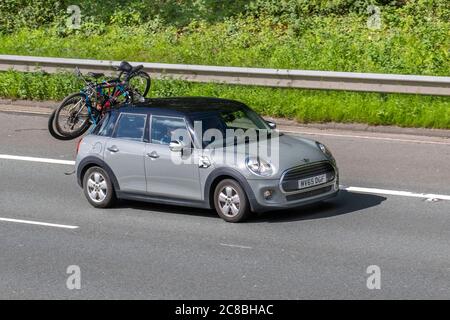 2015 Mini Cooper gris vélos auto vélos cycles sur le porte-bagages de toit de voiture; véhicules de circulation de véhicule en mouvement, voitures de conduite sur les routes du Royaume-Uni, moteurs, conduite sur le réseau d'autoroute M6. Banque D'Images