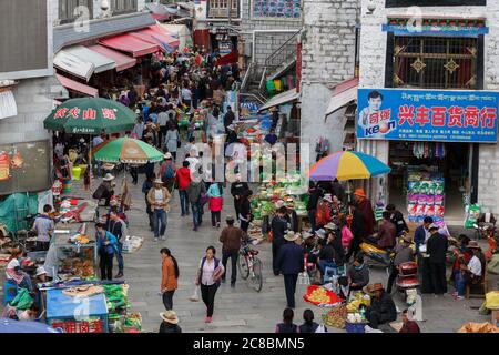Lhassa, Tibet / Chine - 29 juillet 2017: Vue sur le marché de rue bondé dans une allée de la capitale du Tibet Lhassa. Les gens shopping, stands avec des légumes et f Banque D'Images