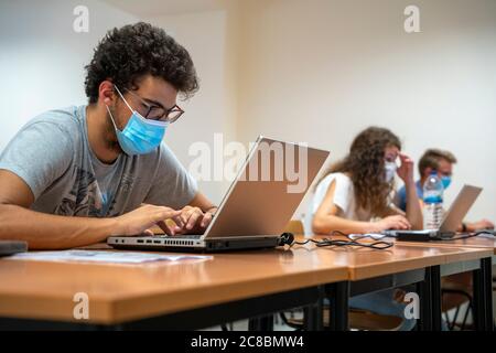 Les élèves portant des masques faciaux en classe pendant la nouvelle pandémie de coronavirus COVID-19 Banque D'Images